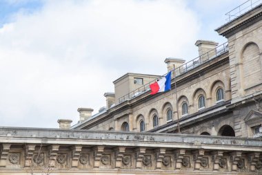 Paris, Fransa, 22 Şubat 202: Bir Fransız bayrağı, Paris 'in ulusal gururunu, şehrin zarif mimarisini ve zamansız cazibesini simgeleyen klasik bir Paris binasında gururla dalgalanıyor