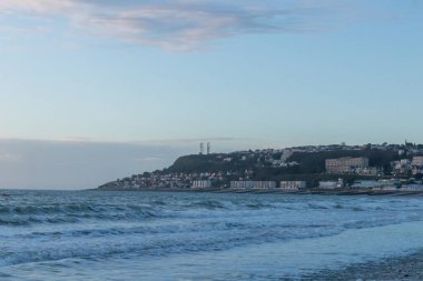 Le Havre, Fransa, 26 Şubat 2025: Normandiya 'nın yüksek uçurumları Le Havre' de, alacakaranlık kıyı şeridini yumuşak, solgun renklerle sararken gün batımının son ışıklarıyla parlıyordu.