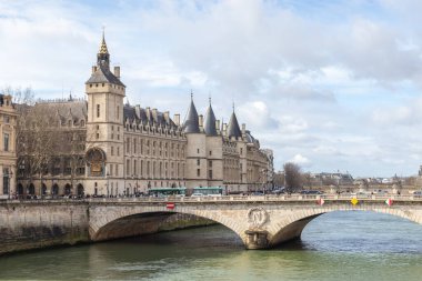 Paris, Fransa - 23 Şubat 2025: Seine nehri üzerindeki Conciergerie Castle ve Değişim Köprüsü manzarası. Castle Conciergerie, Cite Adası 'nın batısında bulunan eski bir hapishane.