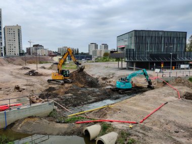 Espoo, Finlandiya - 4 Haziran 2025: Espoo, Finlandiya 'da Meritie inşaatı, Finnoo metro istasyonu. Kazıcılar yolu kazıyor. Bölge inşaat bariyerleriyle kapatıldı.