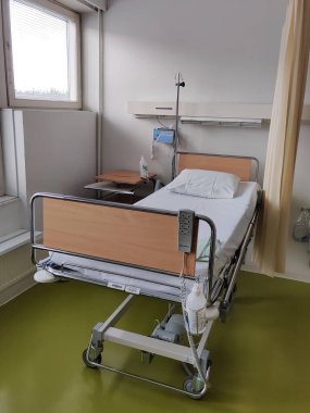 Espoo, Finlandiya - 14 Nisan 2025: Jorvin Hastanesi 'ndeki hastane yatağı (Jorvinsairaala), arka planda beyaz duvarlar, minimum mobilyalar ve tıbbi gereçler bulunan modern bir Finlandiya sağlık merkezi..