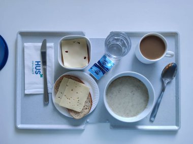 Espoo, Finlandiya - 14 Nisan 2025: HUS Jorvi Hastanesi Jorvinsairaala 'da servis edilen bir hastane kahvaltısı. Finlandiya sağlık sisteminde tipik standart hastane besinini temsil eden dengeli bir gıda seçimi.