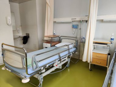 Espoo, Finlandiya - 14 Nisan 2025: Jorvin Hastanesi 'ndeki hastane yatağı (Jorvinsairaala), arka planda beyaz duvarlar, minimum mobilyalar ve tıbbi gereçler bulunan modern bir Finlandiya sağlık merkezi..