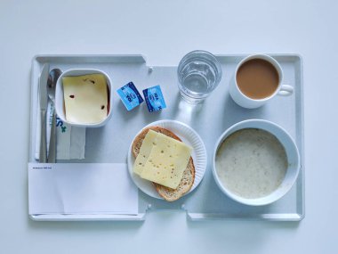 Espoo, Finlandiya - 14 Nisan 2025: HUS Jorvi Hastanesi Jorvinsairaala 'da servis edilen bir hastane kahvaltısı. Finlandiya sağlık sisteminde tipik standart hastane besinini temsil eden dengeli bir gıda seçimi.
