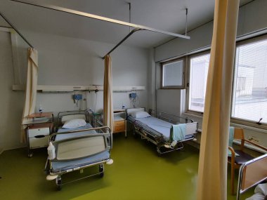 Espoo, Finlandiya - 14 Nisan 2025: Jorvi Hastanesi veya Jorvinsairaala 'daki hastane odası, yan raylı hastane yatakları, tıbbi ekipmanlar ve bir komodin, tipik modern Finlandiya kamu sağlık hizmetleri tesisleri