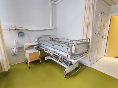 Espoo, Finlandiya - 14 Nisan 2025: Jorvin Hastanesi 'ndeki hastane yatağı (Jorvinsairaala), arka planda beyaz duvarlar, minimum mobilyalar ve tıbbi gereçler bulunan modern bir Finlandiya sağlık merkezi..