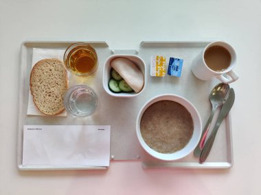 Espoo, Finlandiya - 14 Nisan 2025: HUS Jorvi Hastanesi Jorvinsairaala 'da servis edilen bir hastane kahvaltısı. Finlandiya sağlık sisteminde tipik standart hastane besinini temsil eden dengeli bir gıda seçimi.