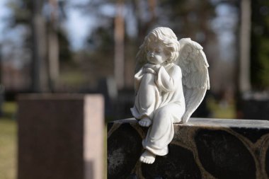 Finlandiya 'da, taş bir melek tarafından işaretlenmiş yalnız bir mezarlığın bulunduğu huzurlu bir Lüterik mezarlık. Çevre sakin ve sakin, saygılı bir atmosferi yansıtıyor.