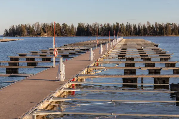 Baharda deniz marinası, sakin bir denizde parmak rıhtımı, boş marina limanı, Finlandiya 'da yelken mevsimi, Suomenoja, liman tesisleri elektrik, su