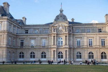 Paris, Fransa - 22 Şubat 2025: Paris 'teki Lüksemburg Bahçesi' nin (Jardin du Lüksemburg) manzarası. Klasik Paris halk parkı sandalyeleri, ziyaretçiler merkez çeşmenin yanında dinleniyor.