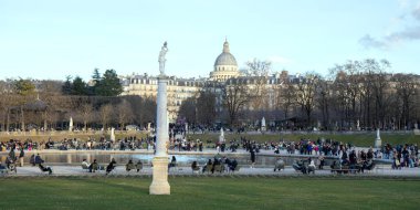 Paris, Fransa - 22 Şubat 2025: Paris 'teki Lüksemburg Bahçesi' nin (Jardin du Lüksemburg) manzarası. Klasik Paris halk parkı sandalyeleri, ziyaretçiler merkez çeşmenin yanında dinleniyor.