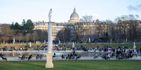 Paris, Fransa - 22 Şubat 2025: Paris 'teki Lüksemburg Bahçesi' nin (Jardin du Lüksemburg) manzarası. Klasik Paris halk parkı sandalyeleri, ziyaretçiler merkez çeşmenin yanında dinleniyor.