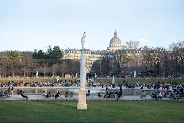 Paris, Fransa - 22 Şubat 2025: Paris 'teki Lüksemburg Bahçesi' nin (Jardin du Lüksemburg) manzarası. Klasik Paris halk parkı sandalyeleri, ziyaretçiler merkez çeşmenin yanında dinleniyor.
