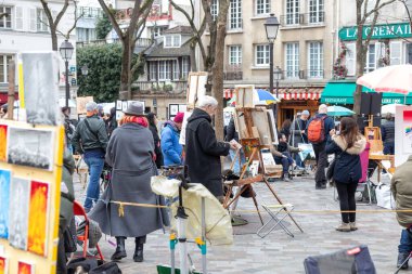 Paris, Fransa - 28 Şubat 2025: Sanatçılar Montmartre Hill 'deki ünlü Place du Tertre' de, Paris 'in bohem cazibesi olan turistler ve şehir manzaraları için portreler çiziyorlar.
