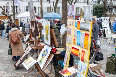 Paris, Fransa - 28 Şubat 2025: Sanatçılar Montmartre Hill 'deki ünlü Place du Tertre' de, Paris 'in bohem cazibesi olan turistler ve şehir manzaraları için portreler çiziyorlar.