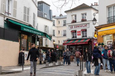 Paris, Fransa - 28 Şubat 2025: Paris Montmartre bölgesinin tarihi binalarla dolu büyüleyici caddeleri. Klasik bir Paris ikonik yeri, bohem cazibesi.