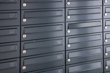 İkamet binaları veya ofis girişlerinde mektup ve paket almak için duvara asılmış posta kutuları.