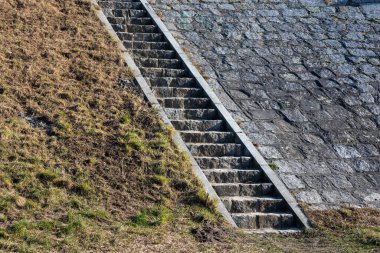 Düzensiz taş dokulara sahip taş basamaklar, eski Avrupa şehrinde tarihi ve büyüleyici bir yüzey yaratıyor, geleneksel ve zamansız bir arka plan.