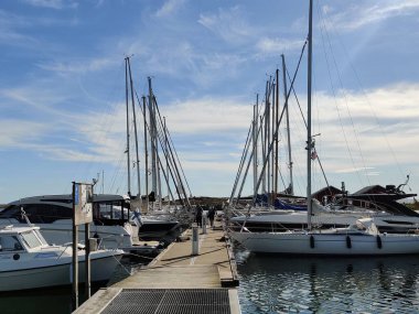 Jurmo, Pargas, Finlandiya - 1 Temmuz 2025: Jurmo adasındaki yat limanı, yaz mevsiminde demirlemiş yelkenliler ve motorlu tekneler, rıhtıma yanaşmış ve güneşli bir günde demirleme şamandıralarına bağlanmış.