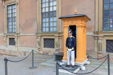 Stockholm, İsveç - 10 Temmuz 2025 Kraliyet Sarayı 'nın girişinde görevli üniformalı bir kraliyet muhafızı İsveç monarşisinin törensel korumasını, geleneği ve onurunu simgeliyor.