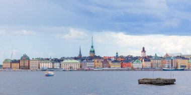 Stockholm, İsveç 'teki Eski Şehir Gamla Stan manzarası. Renkli tarihi binalar, dar sokaklar, geleneksel İskandinav mimarisi ve limana demirlemiş tekneler.