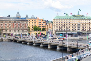 Stockholm, İsveç - 10 Temmuz 2025: Eski Şehir 'in (Gamla Stan) manzarası, Grand Hotel, köprüler ve arabalar, İsveç başkentinin kentsel manzarasını ve tarihi cazibesini yansıtıyor