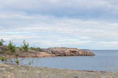 Çimen, deniz ve granit kayaları olan Fin takımadalarından huzurlu bir sahil manzarası. Kırılgan ada ekosistemlerini korumak ve doğal mirası korumak. Jussaro, 2025