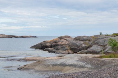 Fin takımadalarından, çam ağaçları, deniz ve granit kayaları olan huzurlu bir sahil manzarası. Kırılgan ada ekosistemlerini korumak ve doğal mirası korumak. Jussaro, 2025