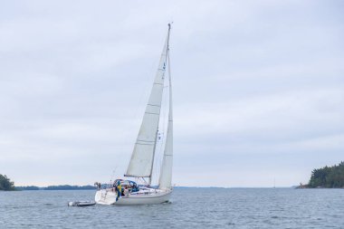 Baş genoa ve ana yelkenli İsveç bayrağı altında Finlandiya Körfezi 'nde rüzgara karşı denizde süzülür. Huzurlu bir deniz manzarası, gezinti, tatil eğlencesi, yelkenli yarışı ruhu.