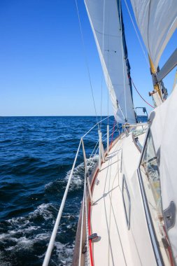 Genoa ve ana yelken altında lüks bir yat, Baltık Denizi 'nin dalgalarını kesiyor, Finlandiya Körfezi' nde. Güverteden pruvaya, direğe ve yelkenlere bak, hız, hareket ve yat maceralarını vurgula