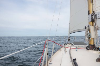 Genoa ve ana yelken altında lüks bir yat, Baltık Denizi 'nin dalgalarını kesiyor, Finlandiya Körfezi' nde. Güverteden pruvaya, direğe ve yelkenlere bak, hız, hareket ve yat maceralarını vurgula