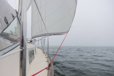 Genoa ve ana yelken altında lüks bir yat, Baltık Denizi 'nin dalgalarını kesiyor, Finlandiya Körfezi' nde. Güverteden pruvaya, direğe ve yelkenlere bak, hız, hareket ve yat maceralarını vurgula