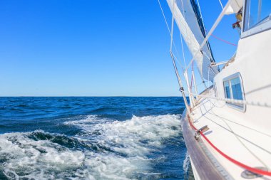 Genoa ve ana yelken altında lüks bir yat, Baltık Denizi 'nin dalgalarını kesiyor, Finlandiya Körfezi' nde. Güverteden pruvaya, direğe ve yelkenlere bak, hız, hareket ve yat maceralarını vurgula