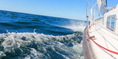 Genoa ve ana yelken altında lüks bir yat, Baltık Denizi 'nin dalgalarını kesiyor, Finlandiya Körfezi' nde. Güverteden pruvaya, direğe ve yelkenlere bak, hız, hareket ve yat maceralarını vurgula