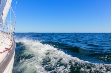 Genoa ve ana yelken altında lüks bir yat, Baltık Denizi 'nin dalgalarını kesiyor, Finlandiya Körfezi' nde. Güverteden pruvaya, direğe ve yelkenlere bak, hız, hareket ve yat maceralarını vurgula
