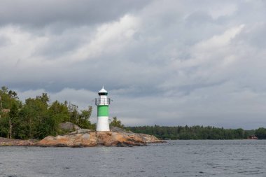 Sahil kayalıklarındaki deniz kanalı işaretleri, yeşil tepeli, kanalın kenarını gösteriyor. Baltık Denizi 'nde kıyı seyrüsefer yardımı, güvenliği, deniz rehberliğini ve kayalık kıyı şeridini vurguluyor