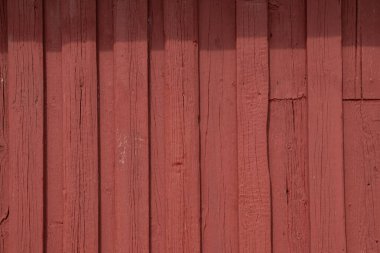 Kırmızı boyalı kereste duvarının yakın çekim dokusu, sürdürülebilir konut işçiliği ekolojik İskandinav geleneğini ve basit kırsal mimariyi yansıtıyor.