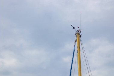 Rüzgar göstergesi gökyüzüne karşı yelkenli direğine monte edildi. Yelken teçhizatı rüzgar yönünü ve hızını gösteriyor. Navigasyon, yat yarışı ve seyir için gerekli teçhizat