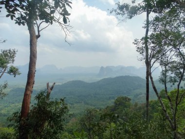 The breathtaking view from Khao Ngon Nak Viewpoint in Krabi, Thailand. The panoramic vista offers a stunning look over the lush green landscape and distant cliffs. clipart