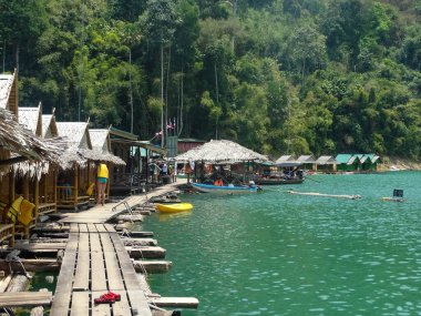 Tayland 'daki Khao Sok Ulusal Parkı' nda su üzerine inşa edilmiş pitoresk bir köy. Yapışkan evler, doğa ve yerel yaşam arasındaki uyumu yansıtıyor..