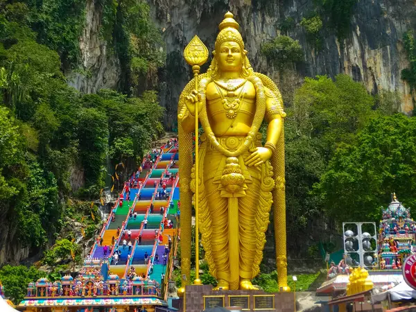 stock image The towering golden statue of Lord Murugan at Batu Caves, Kuala Lumpur, Malaysia. The statue is a major landmark and religious site, attracting thousands of visitors.