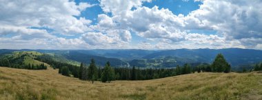 Dağları ve mavi gökyüzü olan güzel bir manzara.