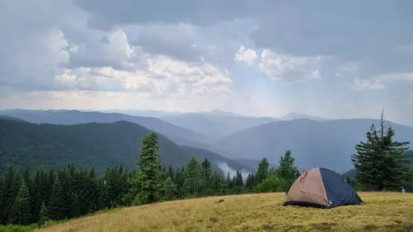 Güneş dağlarda bir sis bulutudur. Dağlar bir turist çadırı..