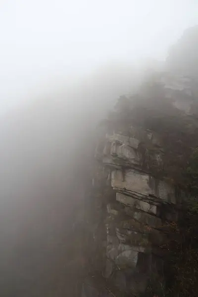 Kalın bir sis, sakin bir manzarada engebeli kayalıkların çevresini sarar ve şafak vakti ruhani bir atmosfer yaratır. Manzara doğada bir sakinlik ve gizem hissi uyandırıyor..