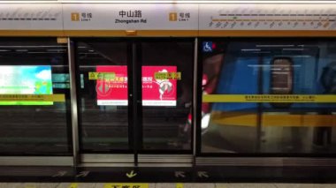 Zhongshan Yolu 'ndaki aktarma istasyonu platformda canlı reklamlar sergiliyor. Parlak grafikler banliyöleri yerel hizmetleri ve yaklaşan toplum etkinliklerini keşfetmeye teşvik ediyor.