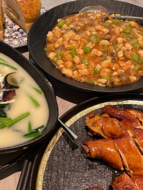 Renkli ve iştah açıcı yemeklerle dolu bir masa, zengin bir sos, taze et ve kızarmış ekmek de dahil olmak üzere çeşitli dokular ve malzemelerin karışımını sergiliyor..