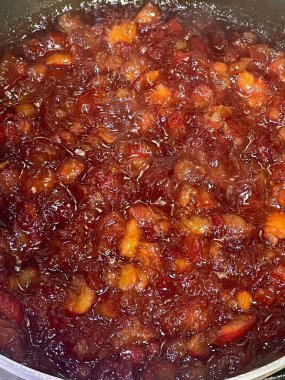 Meyvelerin canlı bir karışımı metal bir tencerede yavaşça pişirir ve tatlı aromalar bırakır. Zengin renkler hoş bir ev yapımı reçel öneriyor. Parlak bir dokusu var. Yayılmak için mükemmel..