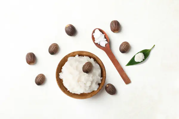 Shea tereyağı fındık üst görünüm ve tahta kaşık içinde Shea tereyağı düz görünüm yatıyordu