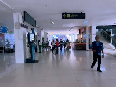 Aceh, Endonezya-20 Aralık 2024: Sultan Iskandar Muda Uluslararası Havalimanı içindeki modern ve ferah koridor. Koridorda hem Endonezya hem de İngilizce olarak parlak ışıklandırma ve açık işaret var.