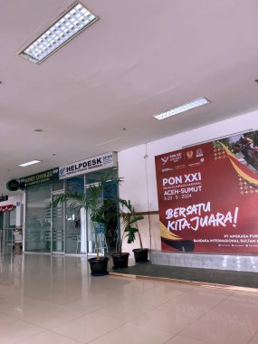 Aceh, Endonezya-20 Aralık 2024: Sultan Iskandar Muda Uluslararası Havalimanı içindeki modern ve ferah koridor. Koridorda hem Endonezya hem de İngilizce olarak parlak ışıklandırma ve açık işaret var.